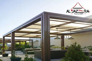 Modern aluminum pergola with retractable beige fabric canopy providing elegant shade in a sunny outdoor patio